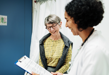 An gray-haired woman talks with her doctor