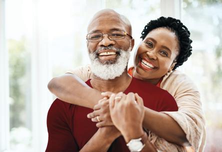 A woman hugging a man from behind.