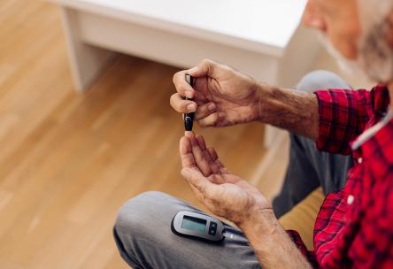 Person using a home blood glucose monitor