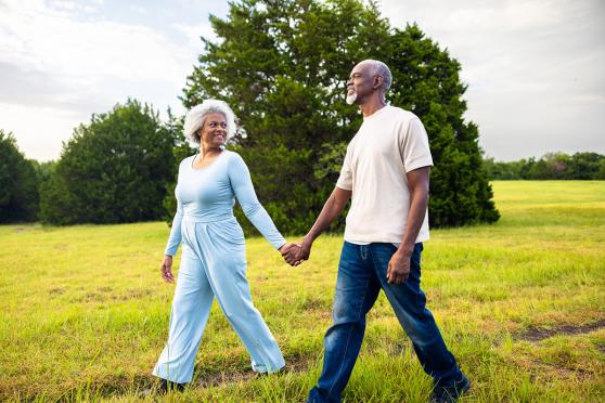 A man and a woman holding hands, walking outside