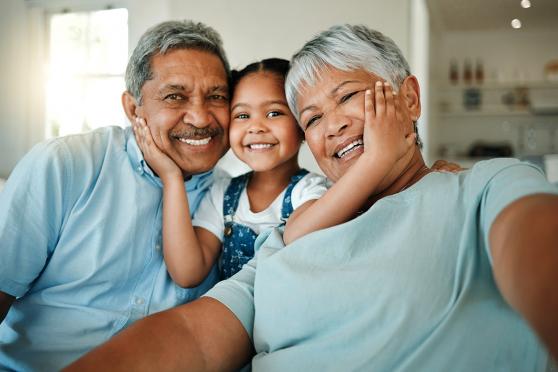 a grandchild hugs her grandparents