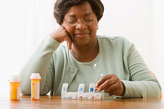 A senior uses a pill organizer